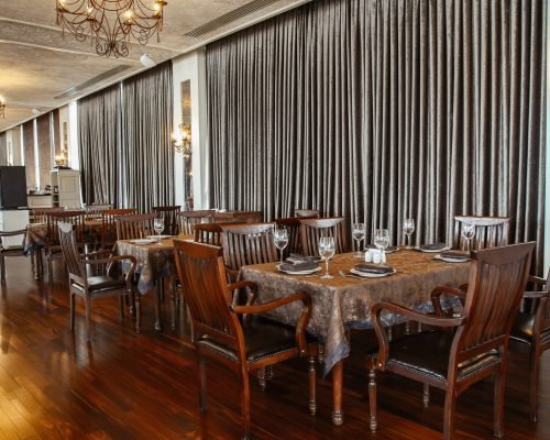 wide restaurant hall with wooden table and chairs for 6 persons