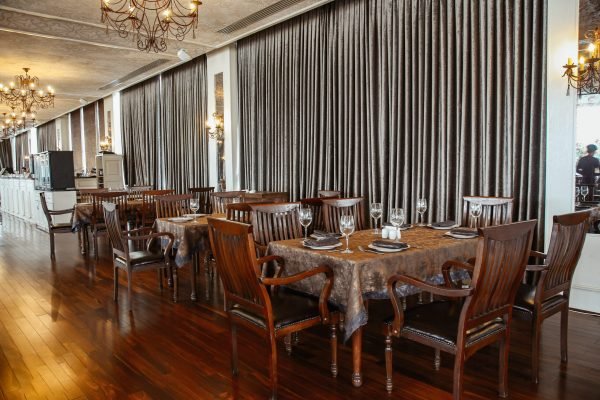 wide restaurant hall with wooden table and chairs for 6 persons